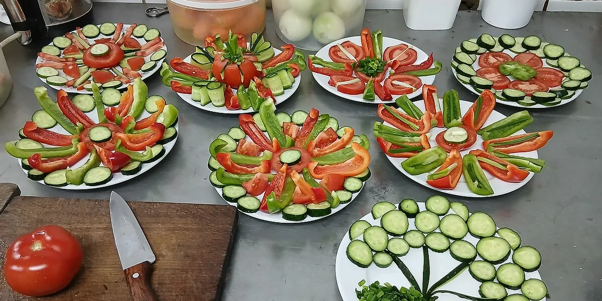 Platos con tomate, pepino y pimiento sobre una mesa de cocina