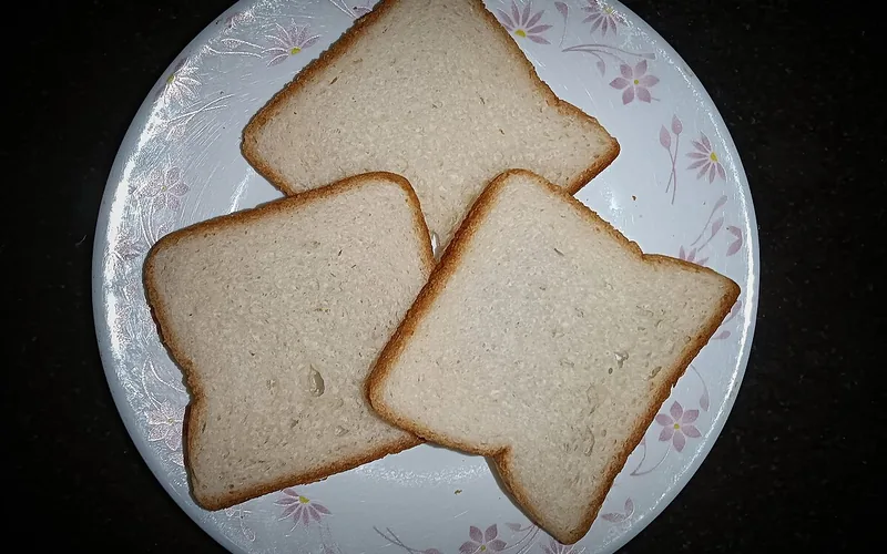 Tres rebanadas de pan en un plato blanco con flores